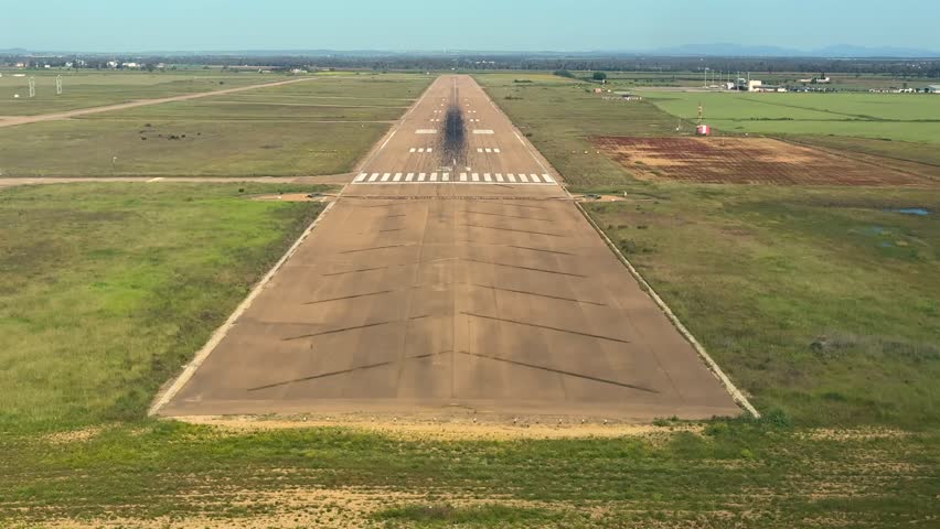 an immersive pilot’s view of a real time approach and alanding on a Isolated african airport worn-out runway under a blue sky