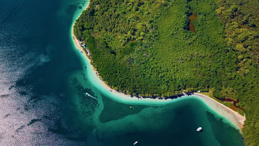 Boat Sailing Along The White Sand Beach In Colon Island In Bocas del Toro, Panama. - aerial shot