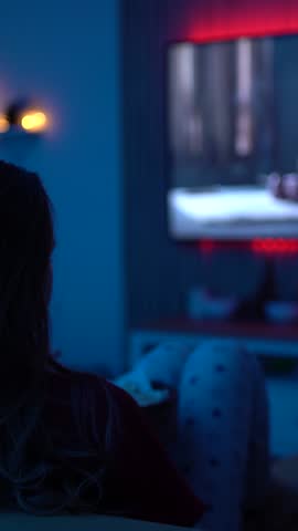 Woman Enjoying a Cozy Movie Night Alone at Home with Dim Lighting and Calm Vibes