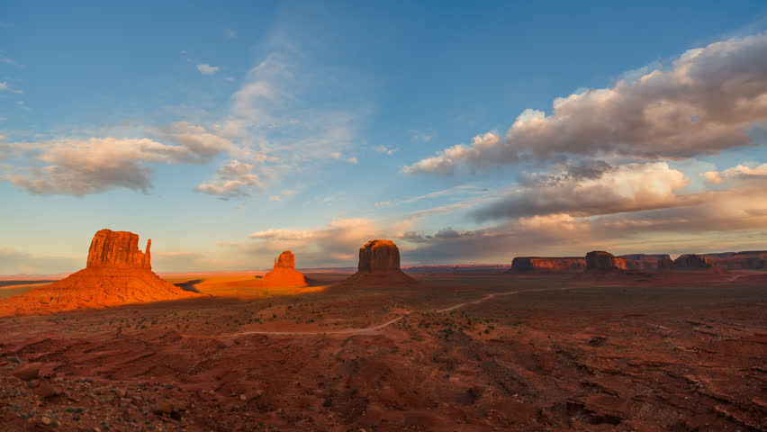 Holy grail time-lapse of Monument Valley with nighttime stars and iconic sandstone buttes in Arizona and Utah desert.