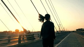 Silhouette of Woman Jogging on Bridge at Sunset - Powered by Shutterstock - Get 15% off with code: PIKWIZARD15