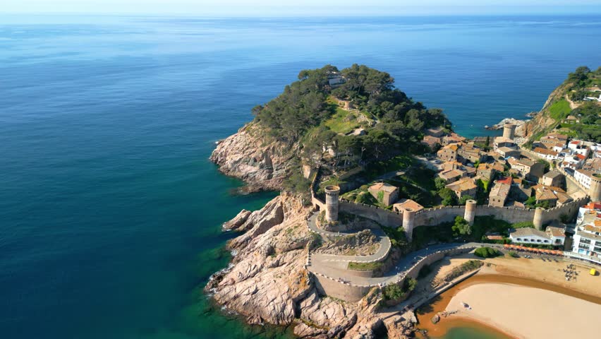 Breathtaking aerial view of tossa de mar, a charming coastal town nestled on the costa brava in catalonia, spain, showcasing its beautiful beach, historic castle, and whitewashed buildings