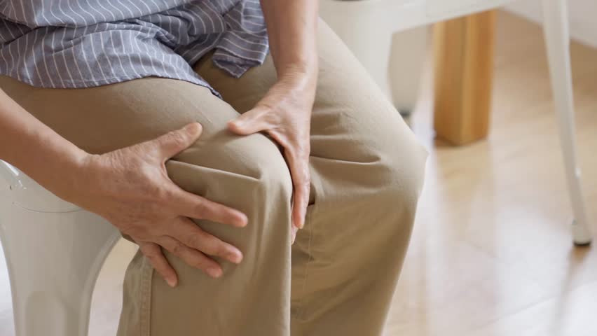 Close up of old woman hands grabing on hurt knee
