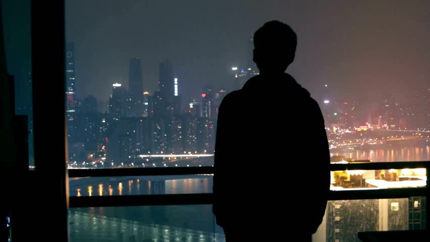 Solitary Figure Contemplating Night Cityscape from Balcony
