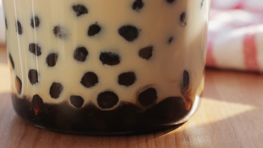 Bubble milk tea with black tapioca in plastic glass, supermarket chinese drink, tasty dessert, close up macro. 