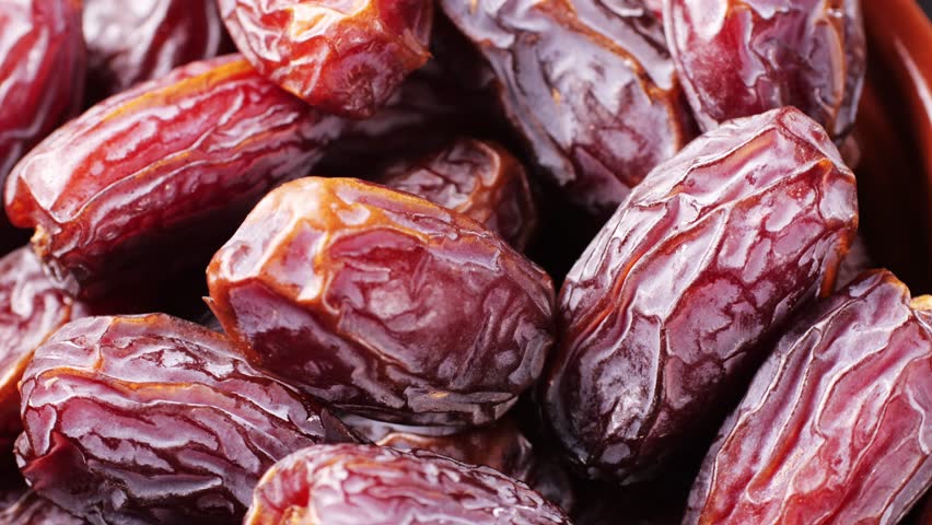 Fresh dates fruits close up on kitchen, close up in supermarket. Eating dried fruits. Vegan, vegetarian food. 