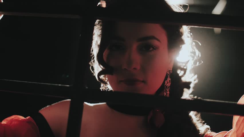 The girl behind bars is trying to seduce the guard. Seduction. Women's prison. The concept of the Carmen opera.