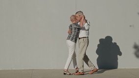 Elderly couple dancing tango in front of white wall - Powered by Shutterstock - Get 15% off with code: PIKWIZARD15