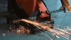 Professional mechanic is cutting steel metal with rotating diamond blade cutter. Steel industry and workshop concept. - Powered by Shutterstock - Get 15% off with code: PIKWIZARD15