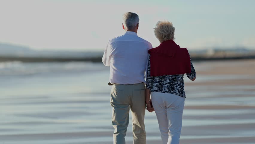 Senior couple walking on beach, enjoying retirement together