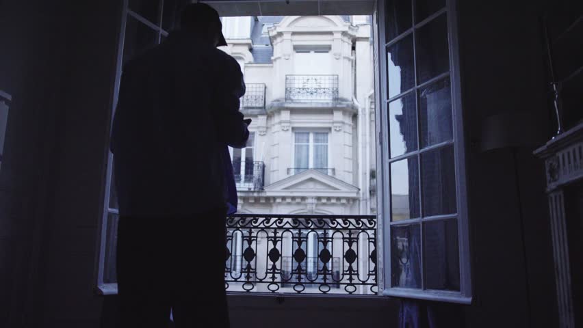 Man reading news on smartphone in parisian hotel room