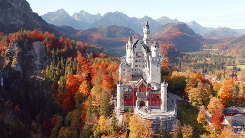 4k drone flight point of view (Ultra High Definition) of Neuschwanstein Castle, 19th-century hilltop fairytale castle. Wonderful autumn scene of Bavaria. Colorful landscape of Alps, Germany, Europe.