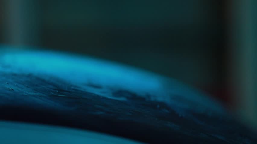 Close-up of fist striking a punching bag, sending dust exploding. Dramatic teal blue rim light illuminates the powerful impact. Gritty texture, intense fitness training concept.