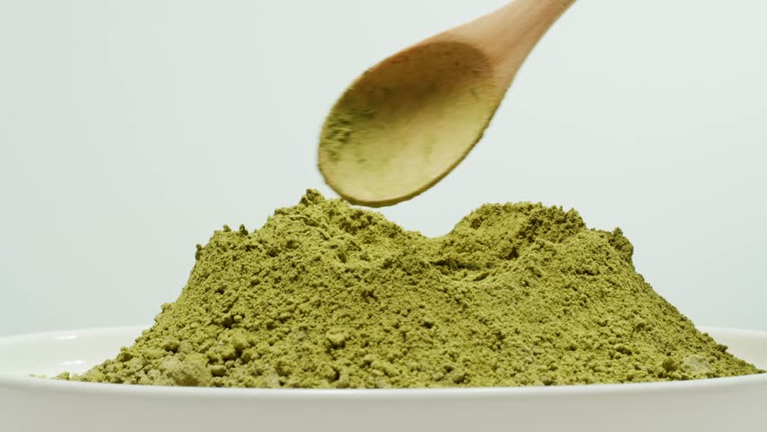 Matcha green tea cooking process, japanese powder green tea in a bowl with bamboo whisk, macro close up in cafe of powder green tea. 