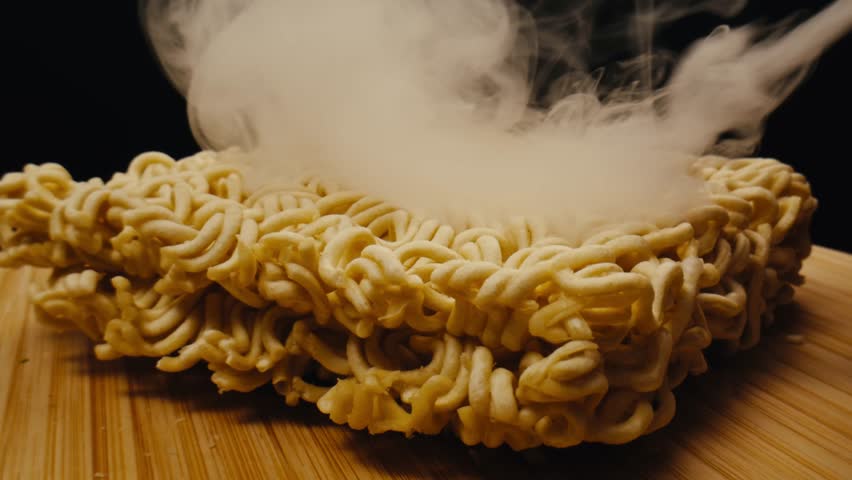 Cooking instant noodles in boiling water with spices close-up. Asian fast food. Instant noodles, or instant ramen, is a type of food consisting of noodles sold in a precooked and dried block with