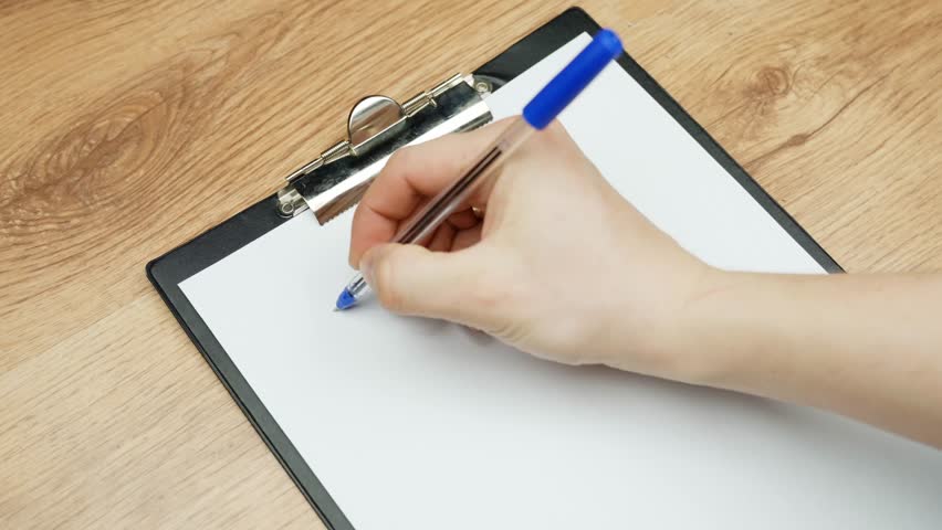 Close up of a hand writing “my business” with a blue pen on white paper clipped to a clipboard, startup concept