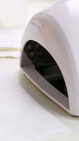 Process of manicure with led lamp. Hand in drying machine. Vertical footage