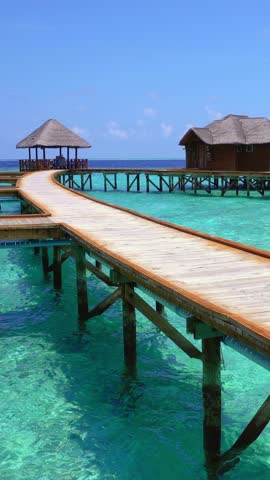 Tropical travel scene with ocean seascape and luxury water bungalows. Vertical footage