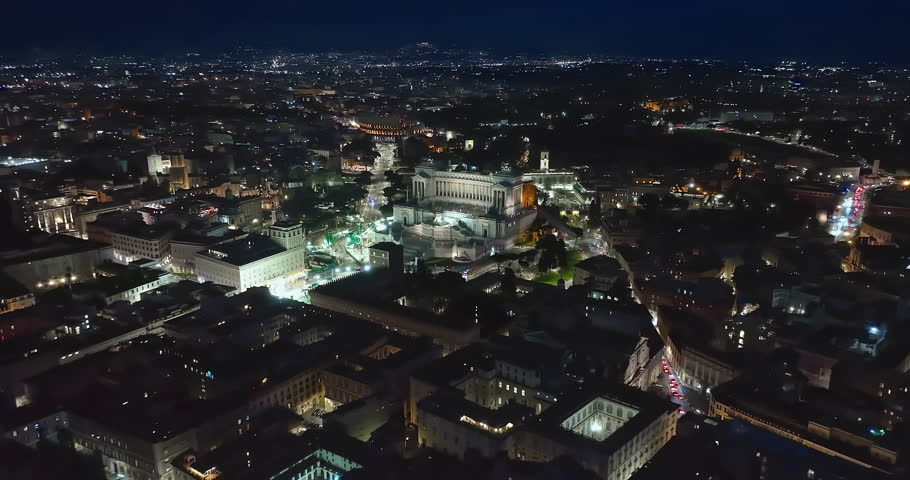 Establishing shot drone flying of historical monument to Vittorio Emanuele II in Rome on Venice Square at night. Downtown Rome, Italy