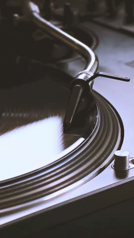 DJ headshell on spinning turntable. Listening the music on vinyl. Closeup. Vertical footage