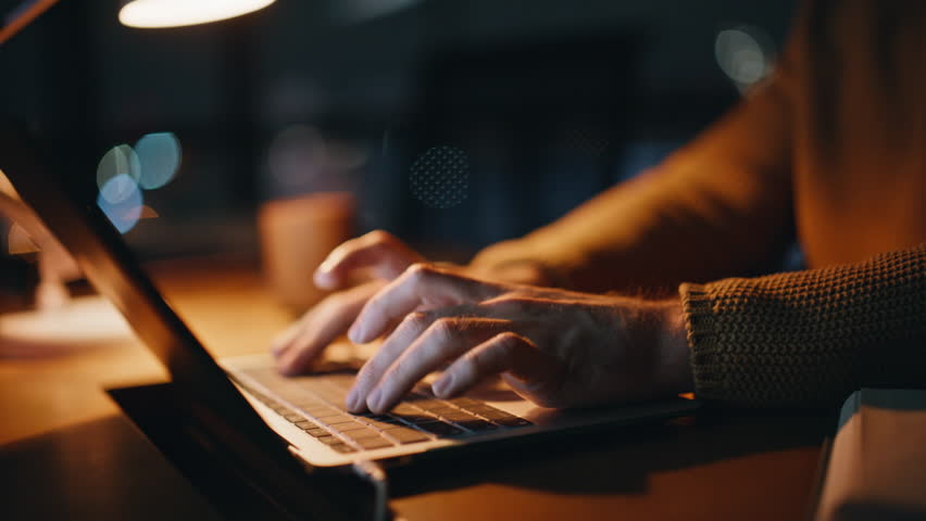 Overloaded manager working overtime in dark workplace closeup. Tensed freelancer typing laptop at night office unmotivated to late project. Tensed businessman thinking on problem touching temples.