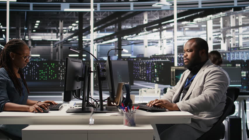 Data center system administrator monitoring servers gear performing AI training and inference tasks. Man working in server room oversees computing systems, managing deep learning operations, camera A