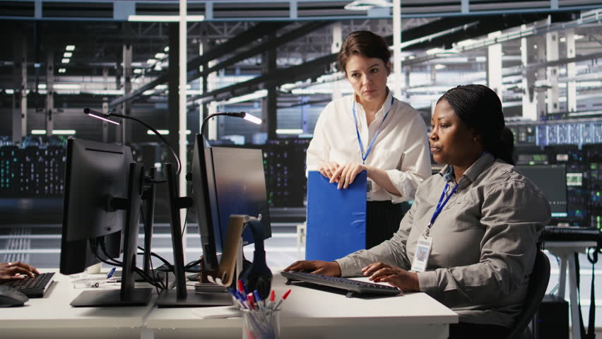 Data center team leader and IT expert reviewing performance dashboards of AI equipment rigs. Server room manager oversee system administrator examining machine learning algorithms on screen, camera A
