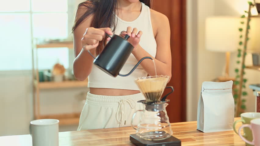 Female hands pouring hot water into a coffee filter