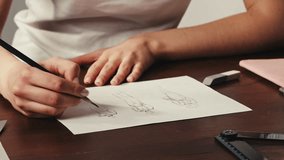 Young woman designer is drawing some clothes by pencil using ruler on white paper . The costume fashion designer making sketches for the work projects close-up. Drawing and sketching lessons - Powered by Shutterstock - Get 15% off with code: PIKWIZARD15
