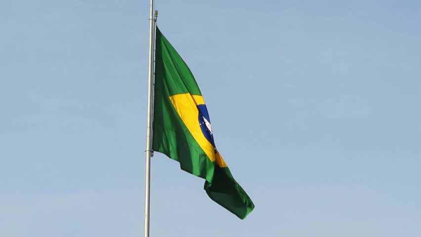 Brazilian national flag waving in the wind with vibrant green, yellow and blue colors, representing national pride and unity of Brazil.