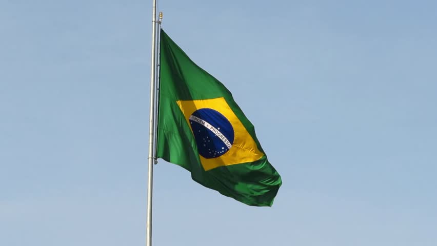 Brazilian national flag waving in the wind with vibrant green, yellow and blue colors, representing national pride and unity of Brazil.