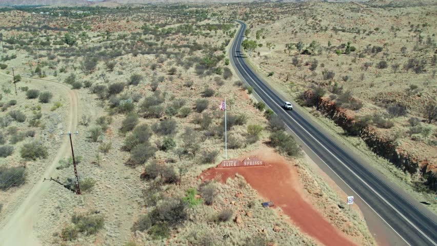 Static aerial view of the Alice Springs sign on the Stuart Highway at Irlpme, a northern suburb of Alice Springs, Mparntwe, Northern Territory, Australia. August 2022.