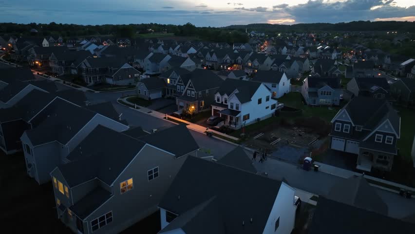 Modern craftsman two-story houses in quiet american housing area. Aerial rising wide shot. Walking group of people on street of suburb district in USA.