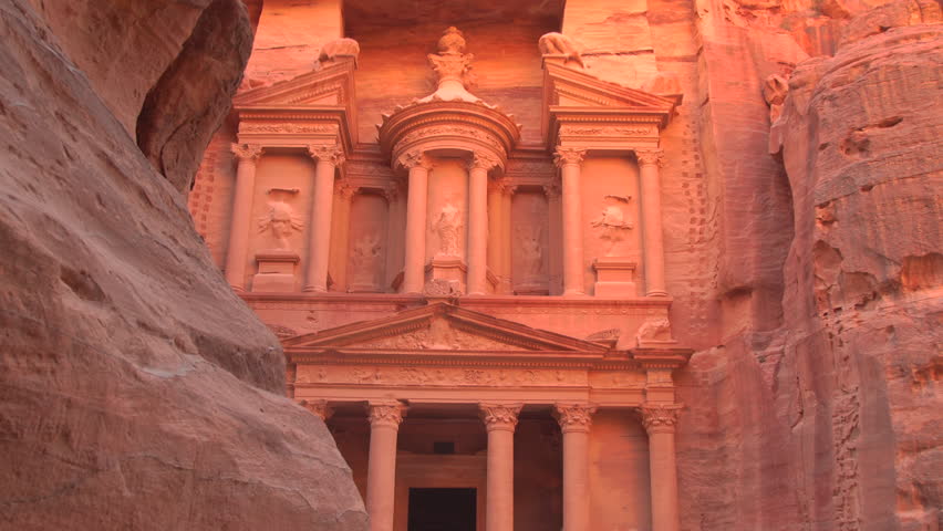 The iconic facade of Al-Khazneh, the Treasury, carved into the sandstone cliffs of the ancient city of Petra, Jordan.
