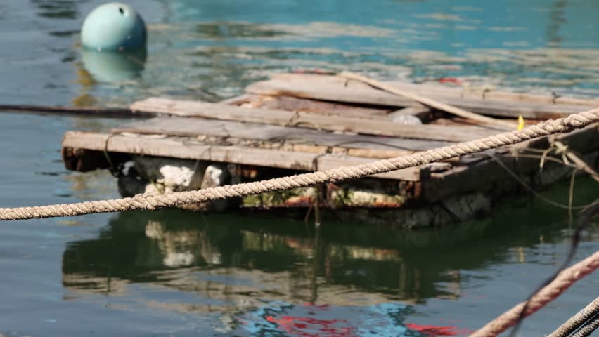 Wooden rafts and boats tied up at a pier