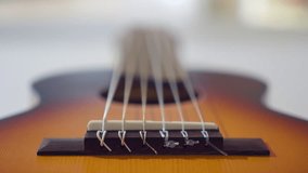 Close-up of classical guitar strings with shallow depth of field. Dolly shot tracking along strings, emphasizing the bridge and texture. Artistic and abstract perspective of a musical instrument. - Powered by Shutterstock - Get 15% off with code: PIKWIZARD15