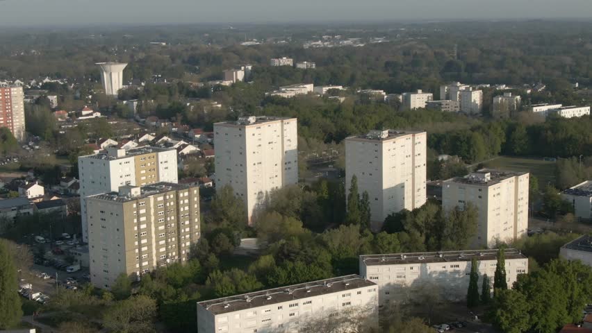 Drone footage showcases modern residential apartment buildings in an urban neighborhood of Nantes. Establishing shot for city life, housing concepts. France