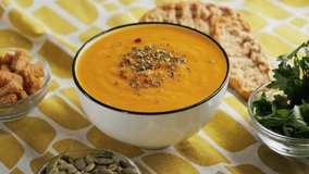 On the table is pumpkin cream soup, served with croutons, pumpkin seeds and parsley. High quality 4k footage - Powered by Shutterstock - Get 15% off with code: PIKWIZARD15