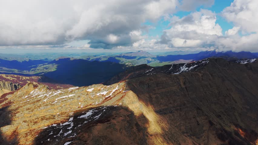 Aerial shot of Dolomites Mountains in Italy showing rocky landscapes and distant views