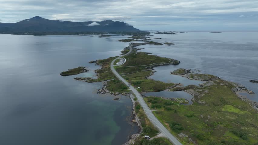 A drone view of the Atlantic Ocean road on Norwegian Sea with dramatic sky and mountain in the background in More og Romsdal county, Norway