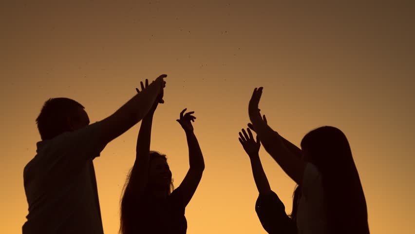 Party, dancing, group of happy people raise their hands to sky in evening. People dance to music at concert raising their hands up. People party in nature, dancing on beach, holiday holiday outdoors