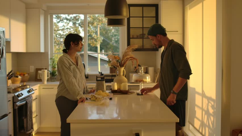Couple in Kitchen, Pregnant Woman Prepares Food and Man Cleans Counter