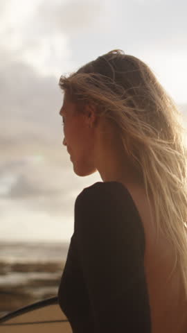 Close Up of Surfer Girl Walking Coastline at Sunset with Wind in Hair