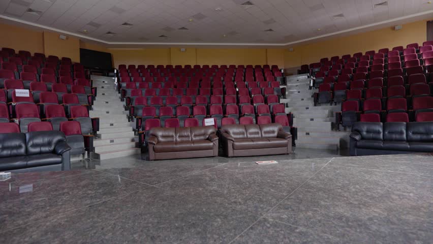 Spacious Auditorium with Empty Rows of Seats and a Stage Area