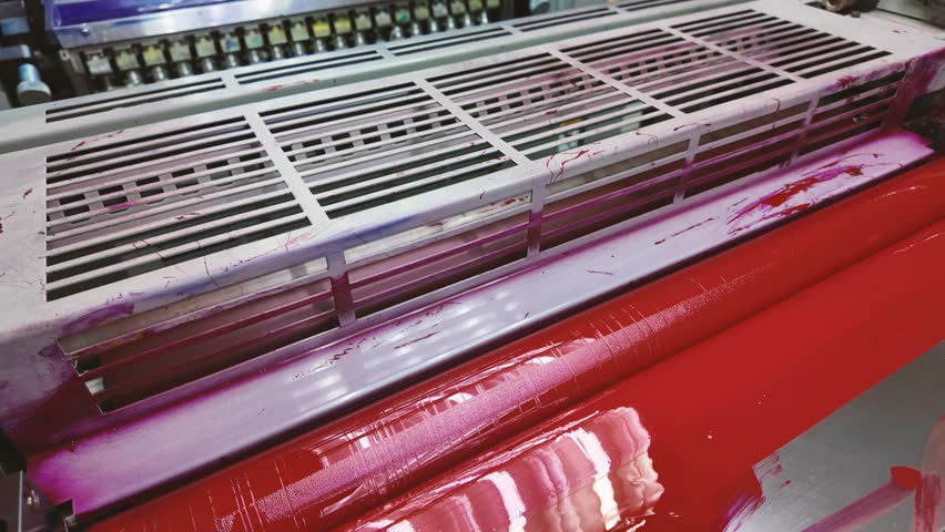Large offset printing press machine. Close up roll colour Red. Production line of industrial printing machine