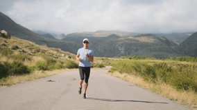 A professional athlete runs a deserted road toward misty mountains until his smartwatch signals the workout end. Slowing down, he stretches, exhales hard, and rests hands on knees to catch his breath. - Powered by Shutterstock - Get 15% off with code: PIKWIZARD15