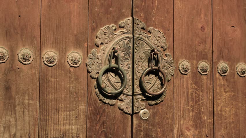 Close-up of Korean Hanok door with traditional ornate metal hardware and natural wood grain, emphasizing the artistry and historical character of the building element