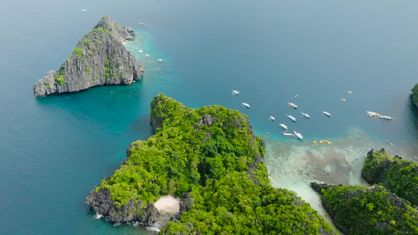 Aerial view of tourist boats and kayaks running over the sea water. Lagoons in Miniloc Island. El Nido, Philippines. Palawan.