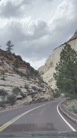 Driving POV in Zion National Park shows white sandstone cliffs