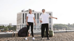 Elderly man and woman practicing yoga and stretching exercises on urban rooftop outdoors. - Powered by Shutterstock - Get 15% off with code: PIKWIZARD15